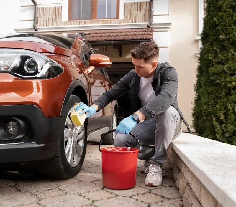 Lavage auto à domicile Aunay-sous-Crécy : professionnel intervenant sur un véhicule